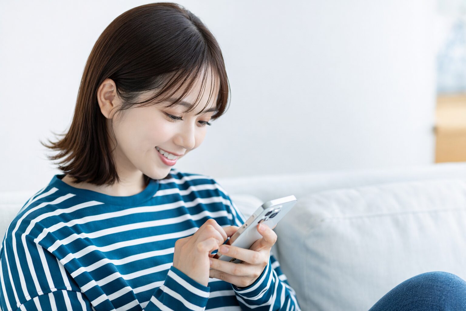 スマートフォンを見ながら首に負担がかかっているイメージ